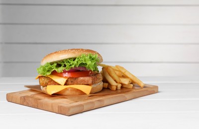 Photo of Delicious tofu burger served with french fries on white table. Space for text