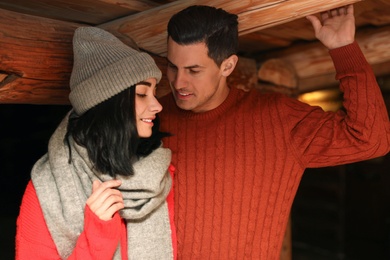 Photo of Lovely couple wearing warm sweaters indoors. Winter season