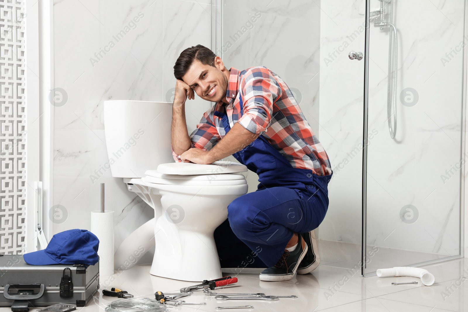 Photo of Professional plumber working with toilet bowl in bathroom