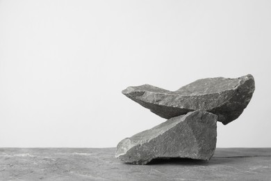 Photo of Presentation for product. Podium made of stones on grey table. Space for text