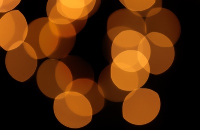 Photo of Blurred view of festive lights on dark background. Bokeh effect