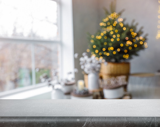 Empty stone surface and blurred view of room decorated for Christmas