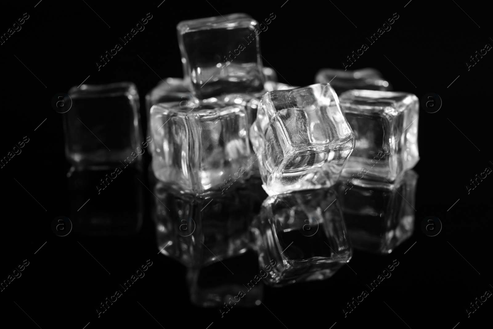 Photo of Pile of crystal clear ice cubes on black background