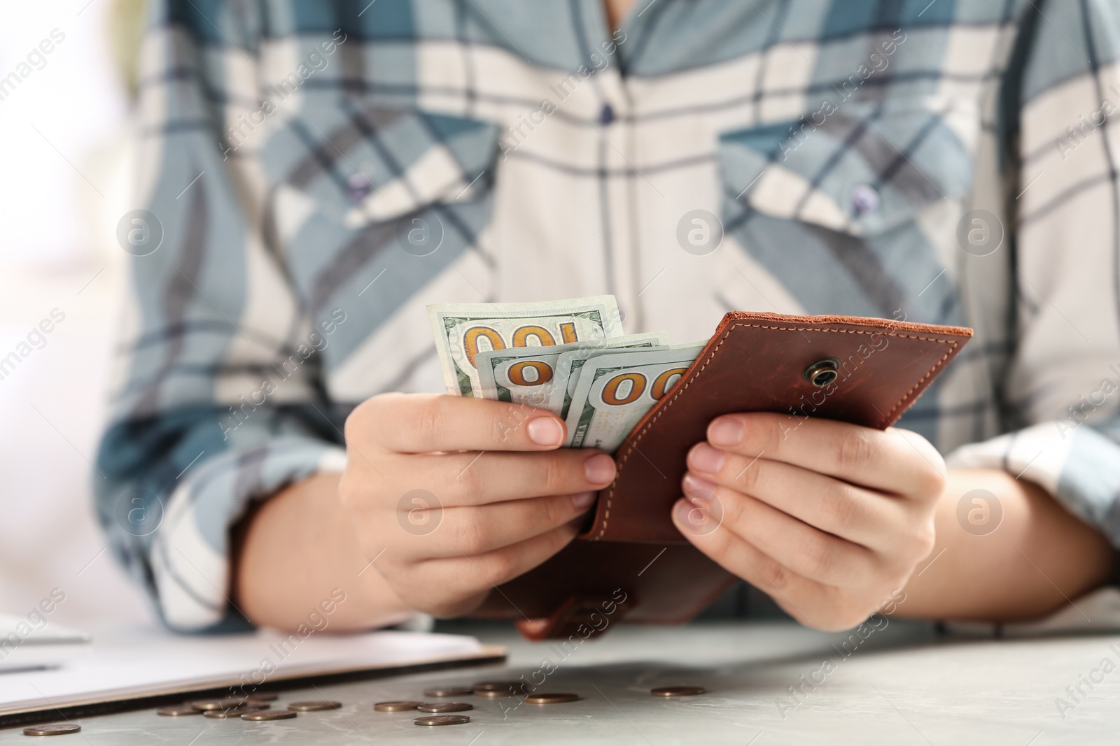 Photo of Woman counting money at light grey table, closeup