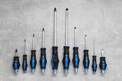 Photo of Set of screwdrivers on grey table, top view