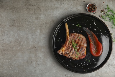 Photo of Flat lay composition with grilled meat steak on grey table. Space for text