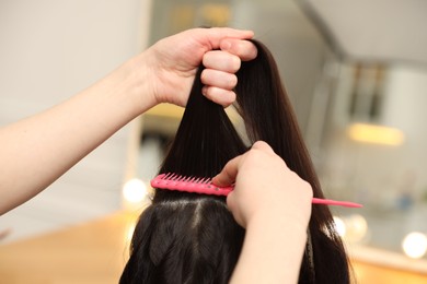 Photo of Hair styling. Professional hairdresser working with client in salon, closeup