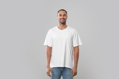 Man wearing white t-shirt on gray background