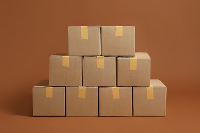 Photo of Stack of many cardboard boxes on brown background