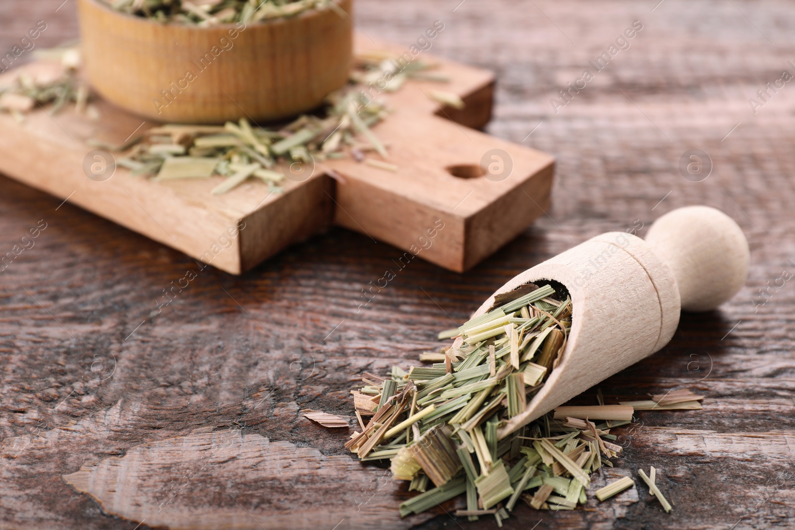 Photo of Scoop with aromatic dried lemongrass on wooden table. Space for text