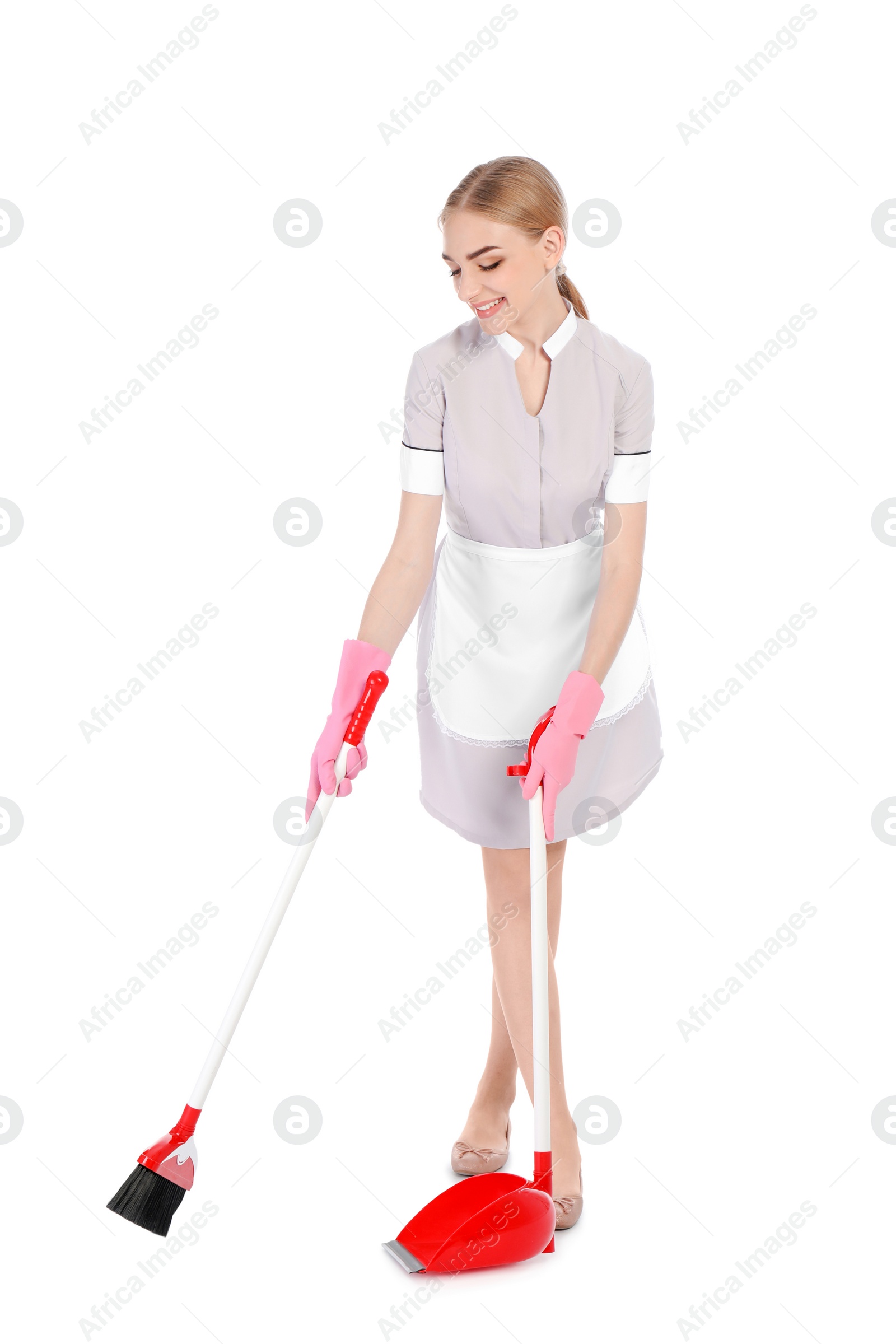 Photo of Young chambermaid with broom and dustpan on white background