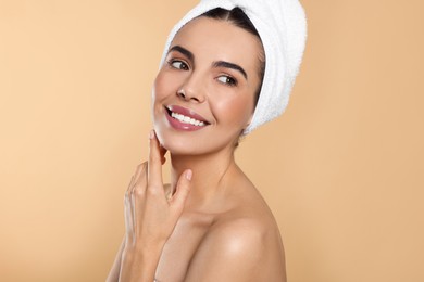 Young woman with towel on beige background. Spa treatment