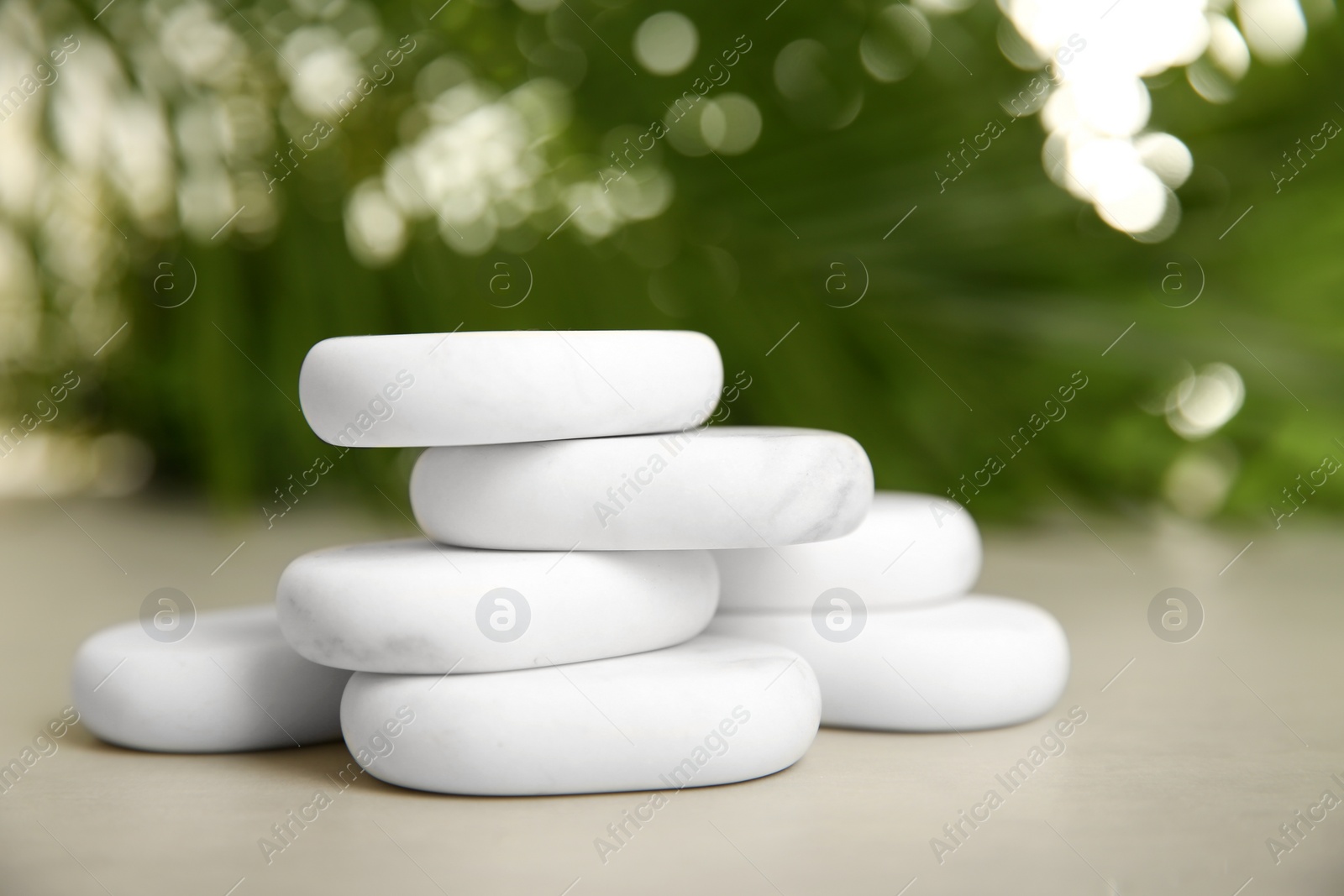 Photo of White spa stones on table against blurred background