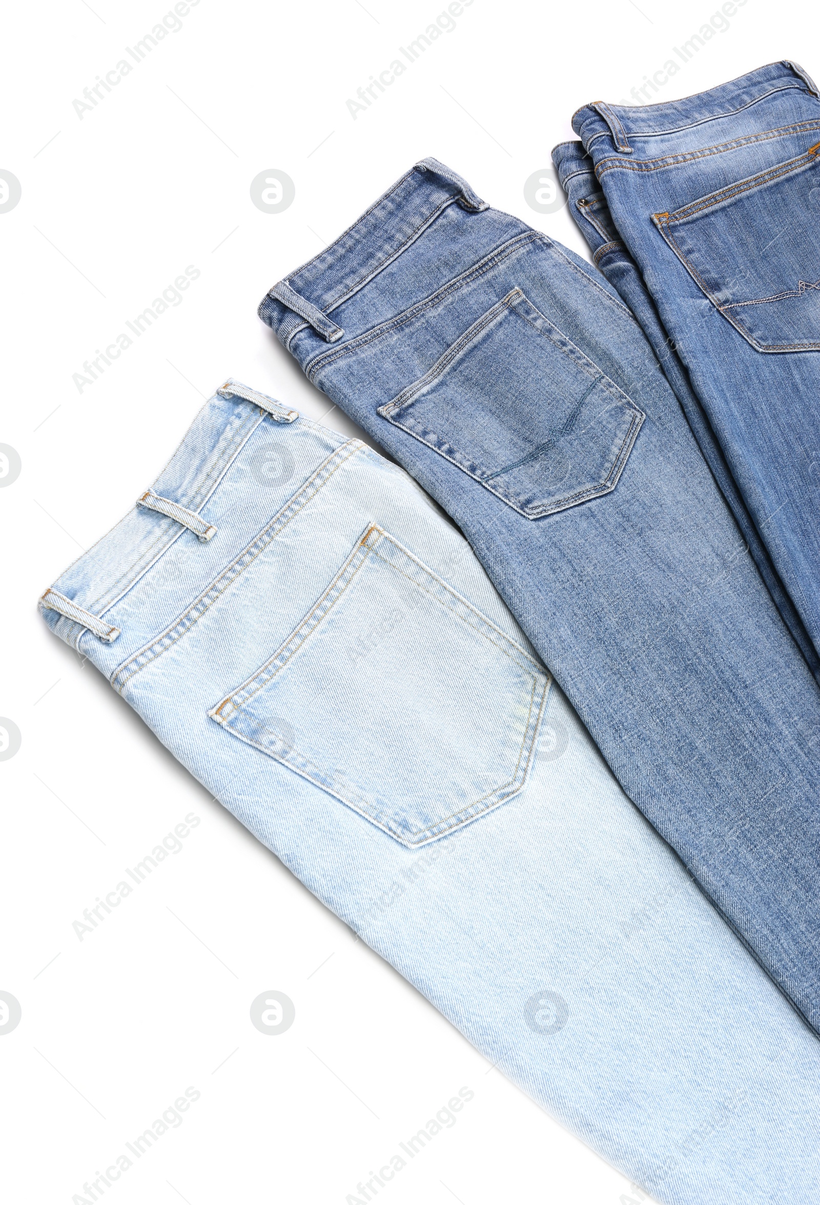 Photo of Different stylish jeans isolated on white, above view