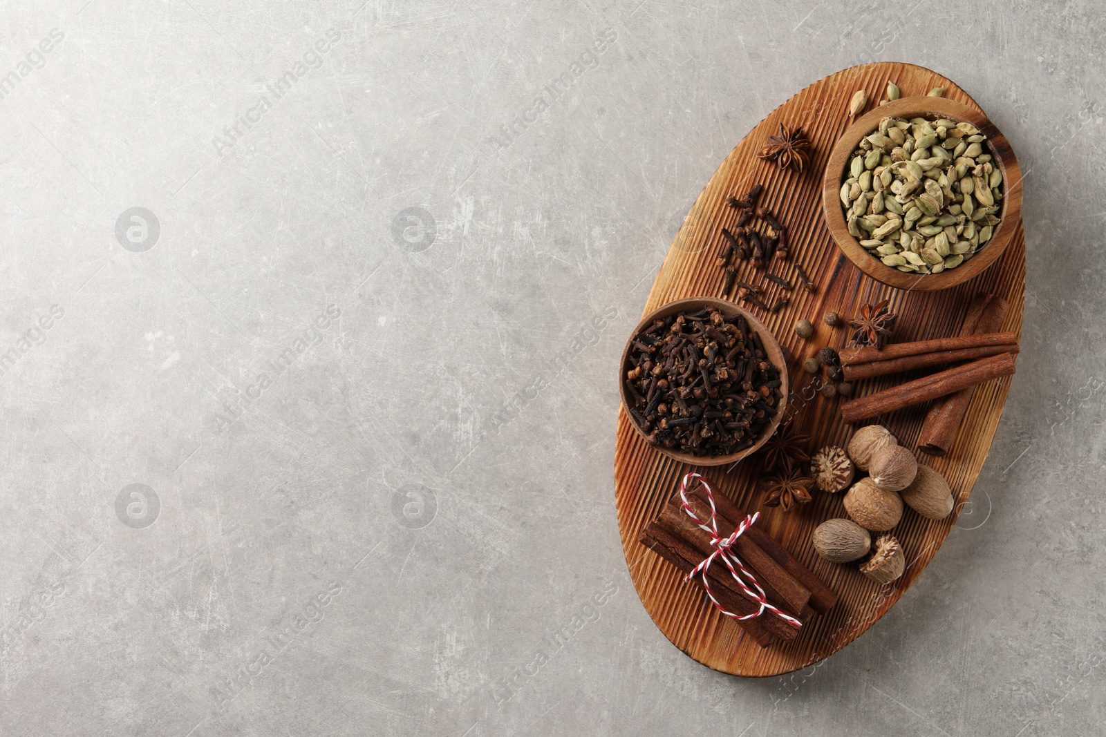 Photo of Different spices on light gray table, top view. Space for text