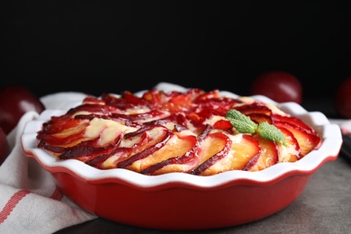 Photo of Delicious cake with plums on grey table, closeup