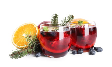 Photo of Aromatic Christmas Sangria drink in glasses, fir branches and ingredients isolated on white