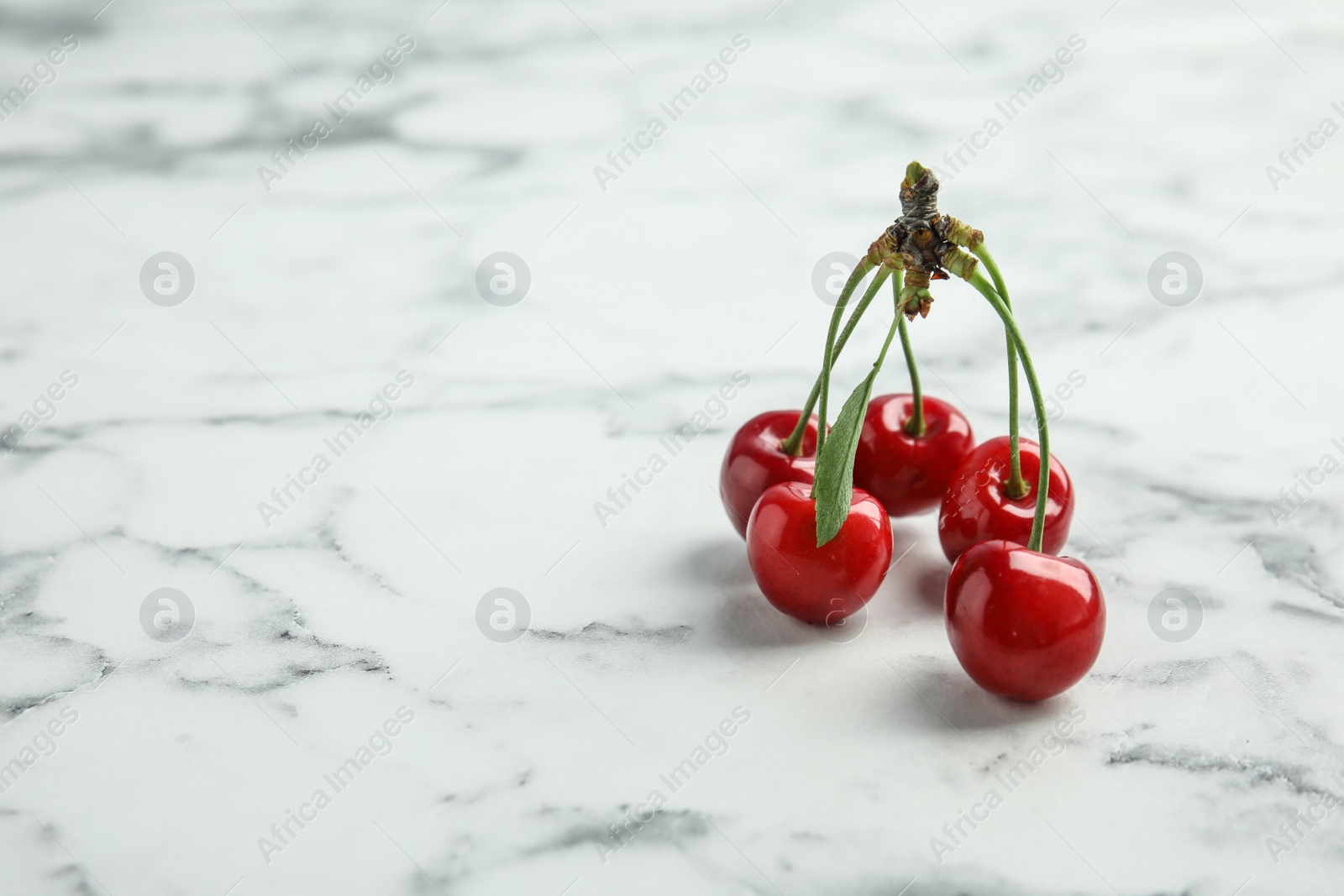 Photo of Sweet red cherries on marble table