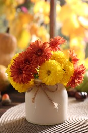 Beautiful colorful chrysanthemum flowers in vase on table indoors