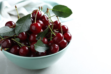 Photo of Sweet juicy cherries on light table, closeup. Space for text