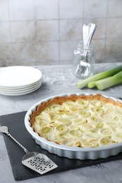 Photo of Freshly baked leek pie served on grey textured table