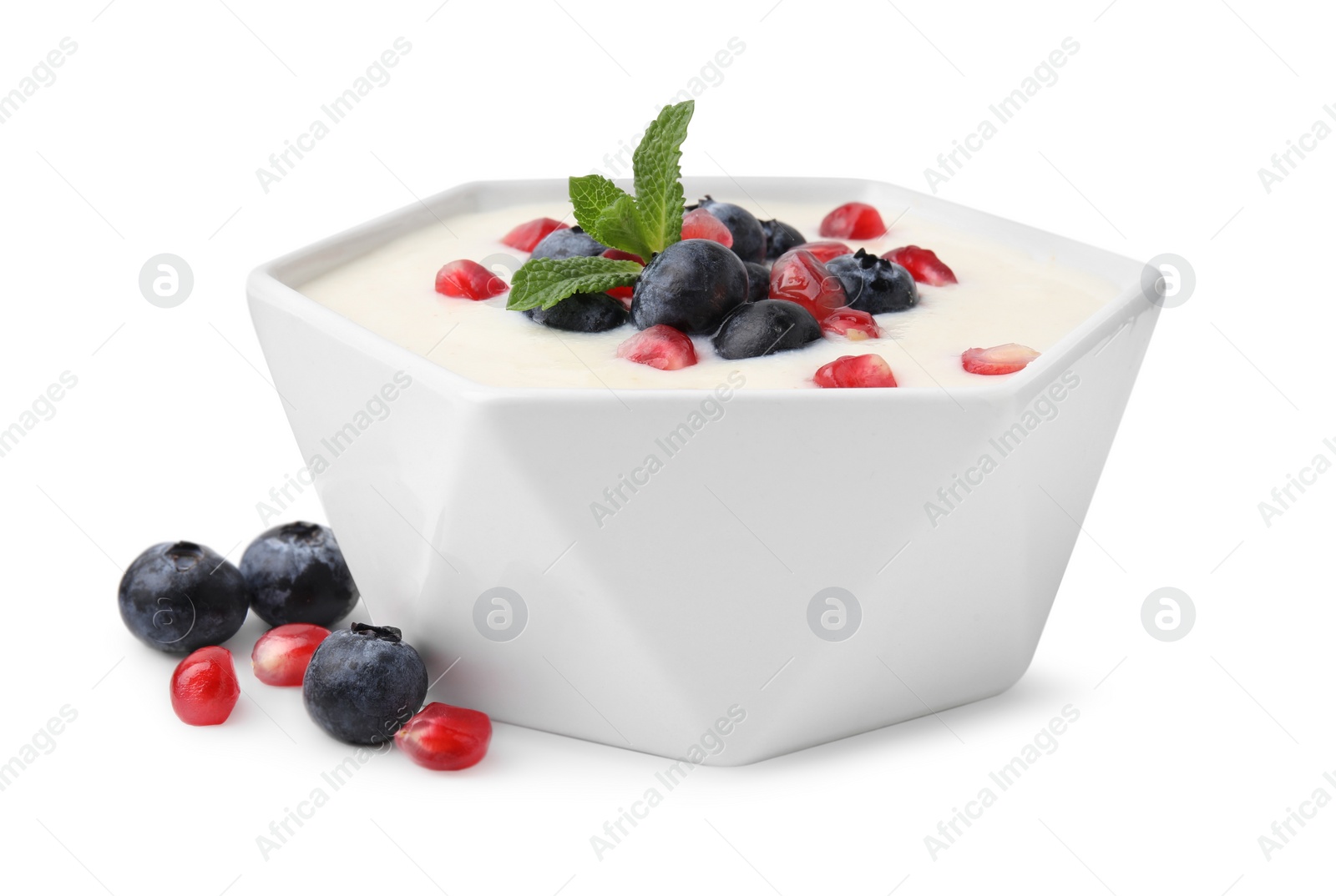 Photo of Bowl of delicious semolina pudding with blueberries, pomegranate and mint isolated on white