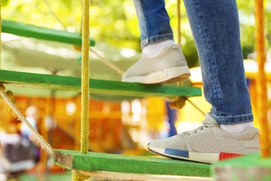 Photo of Child climbing in adventure park, closeup. Summer camp