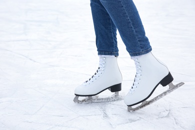 Photo of Woman wearing figure skates on ice rink, closeup. Space for text