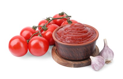 Photo of Organic ketchup in bowl, fresh tomatoes and garlic isolated on white. Tomato sauce