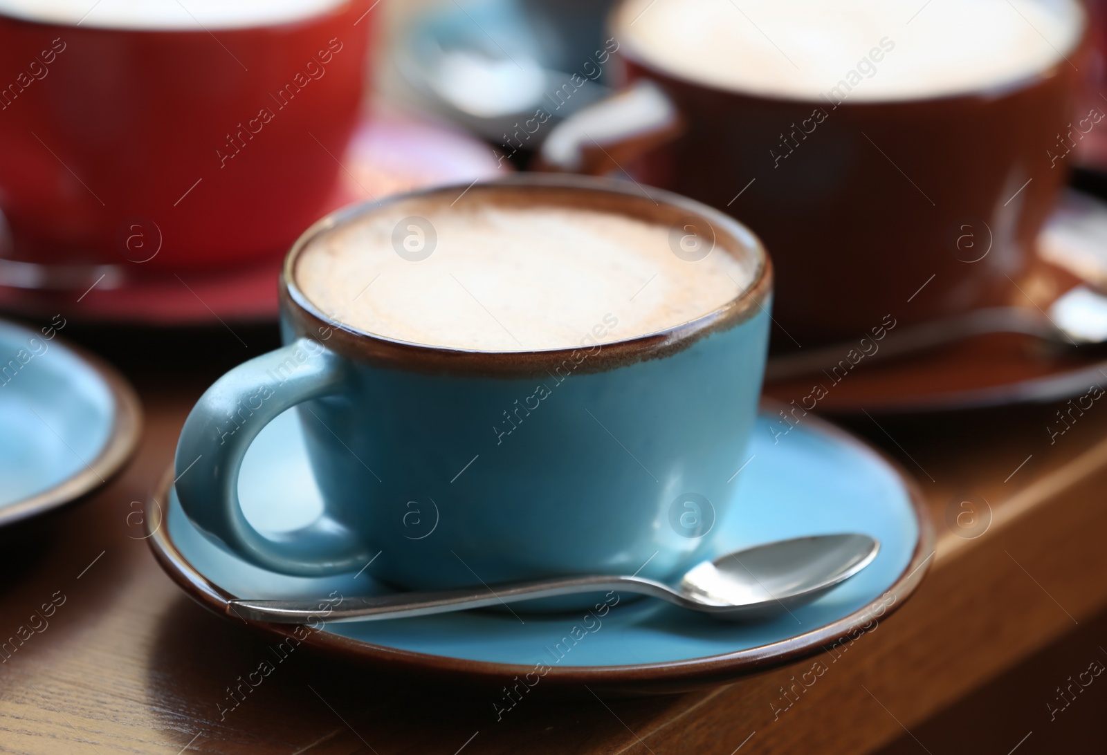 Photo of Cups of fresh aromatic coffee on wooden table, closeup