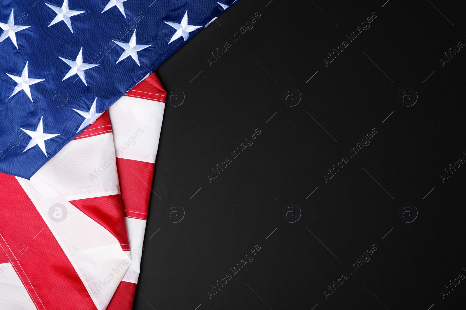 Photo of USA flag on black background, top view. Space for text