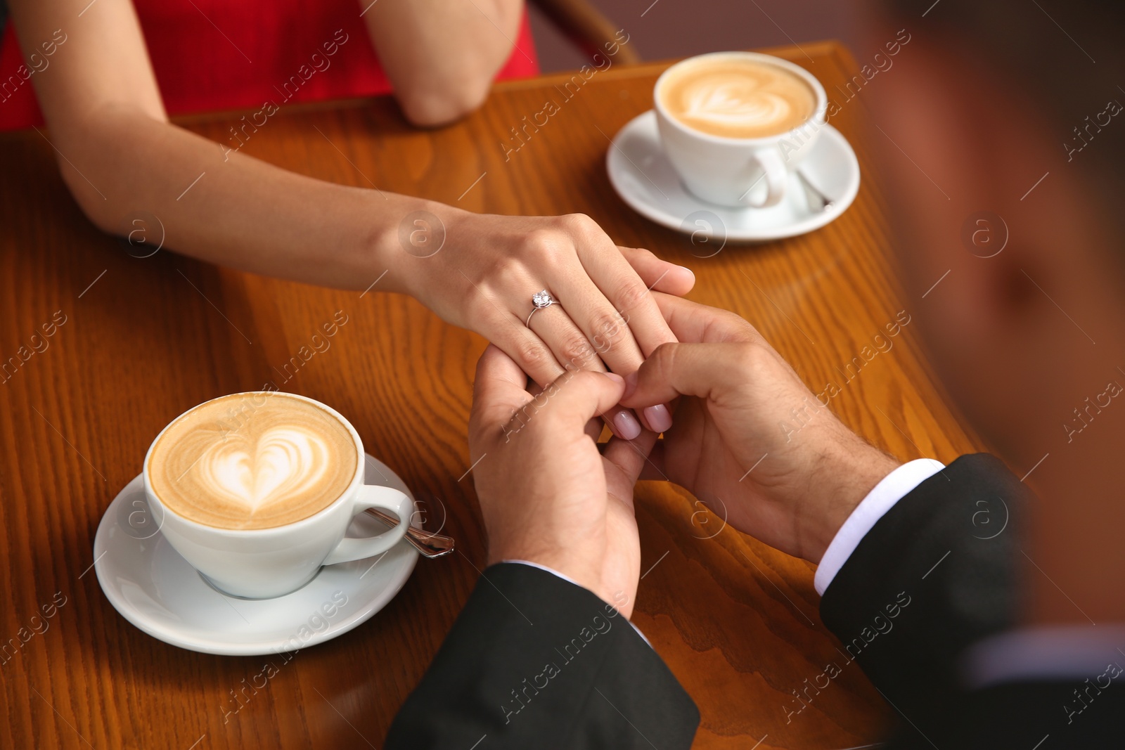 Photo of Man with engagement ring making proposal to his girlfriend in cafe, closeup