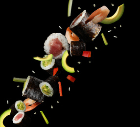 Image of Delicious sushi rolls and ingredients on black background