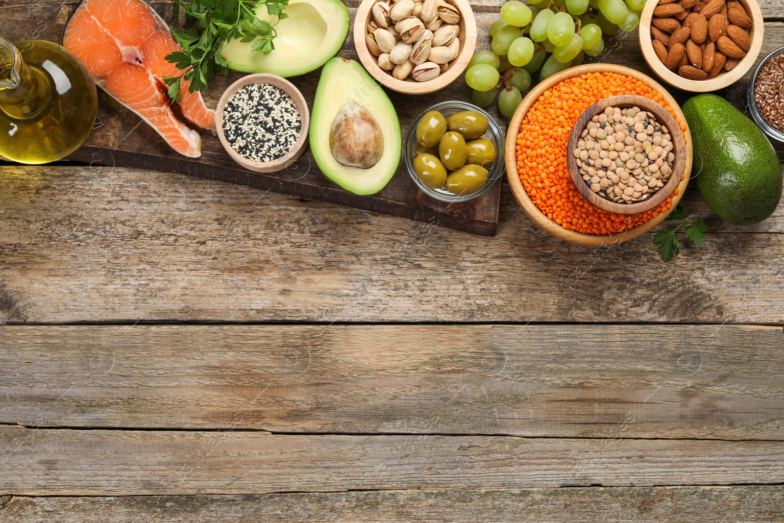 Photo of Different products high in natural fats on wooden table, flat lay. Space for text