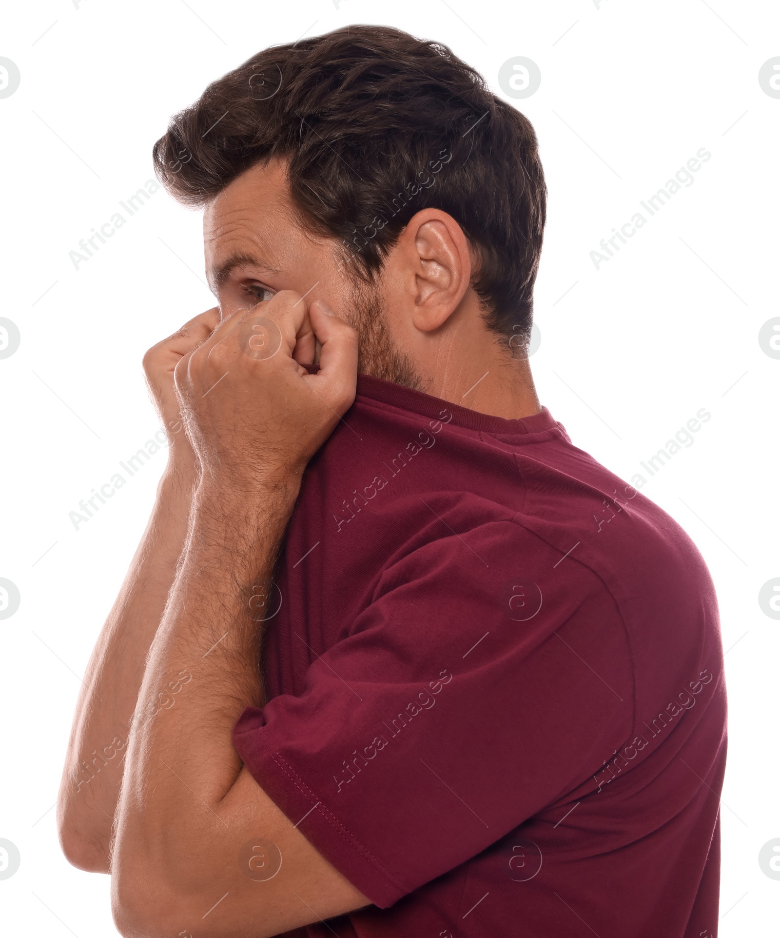 Photo of Man covering face with shirt on white background