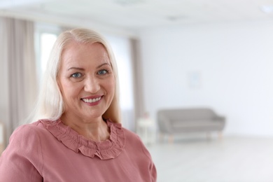 Photo of Portrait of beautiful older woman against blurred background with space for text