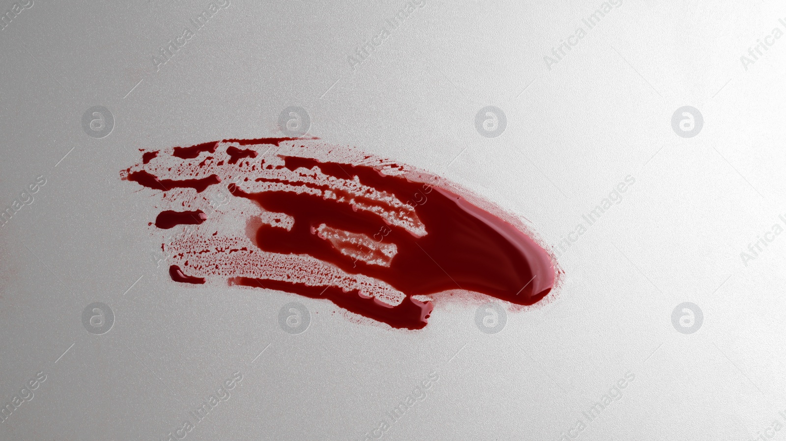 Photo of Stain of blood on grey background, top view