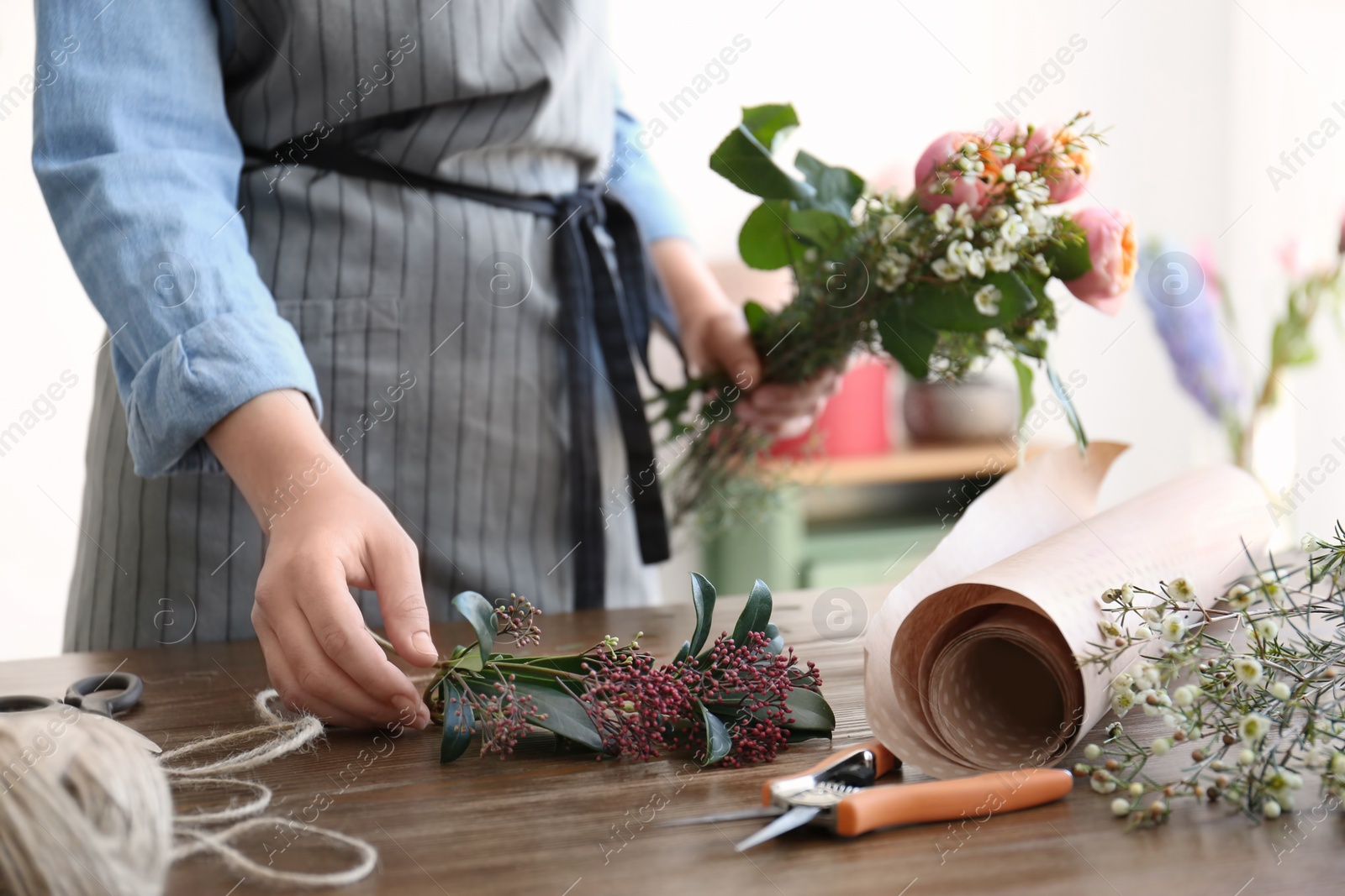 Photo of Female florist creating beautiful bouquet at table