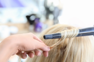 Professional hairdresser working with client in salon