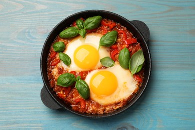 Photo of Delicious Shakshuka on light blue wooden table, top view