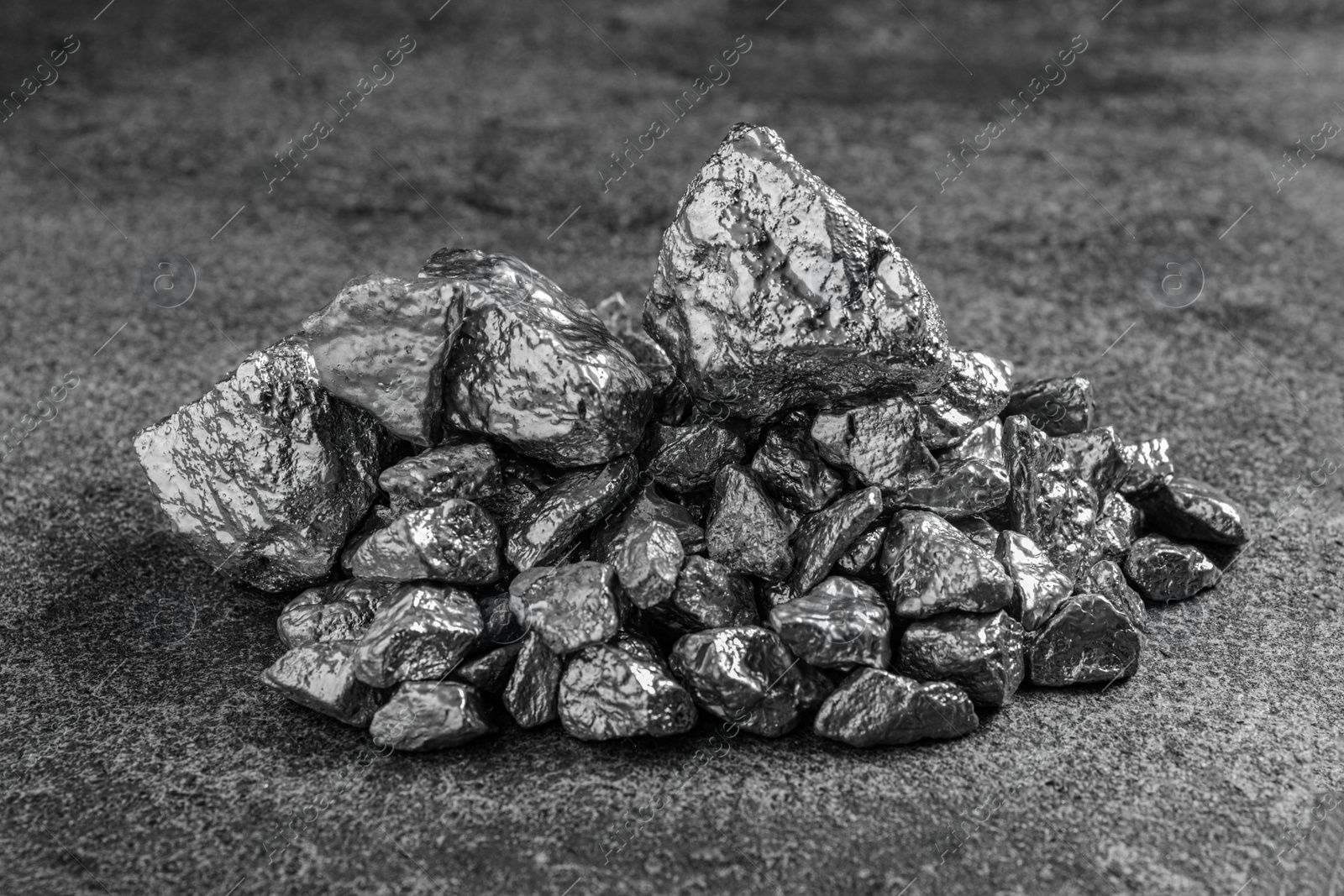 Photo of Pile of silver nuggets on grey textured table, closeup