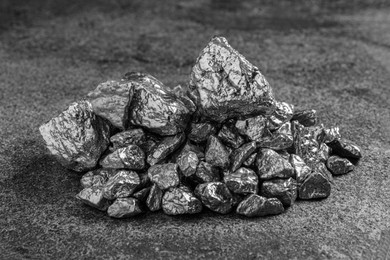 Photo of Pile of silver nuggets on grey textured table, closeup