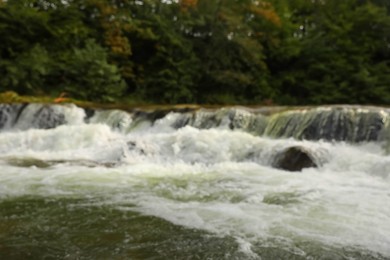 Photo of Blurred view of river with rapids near forest
