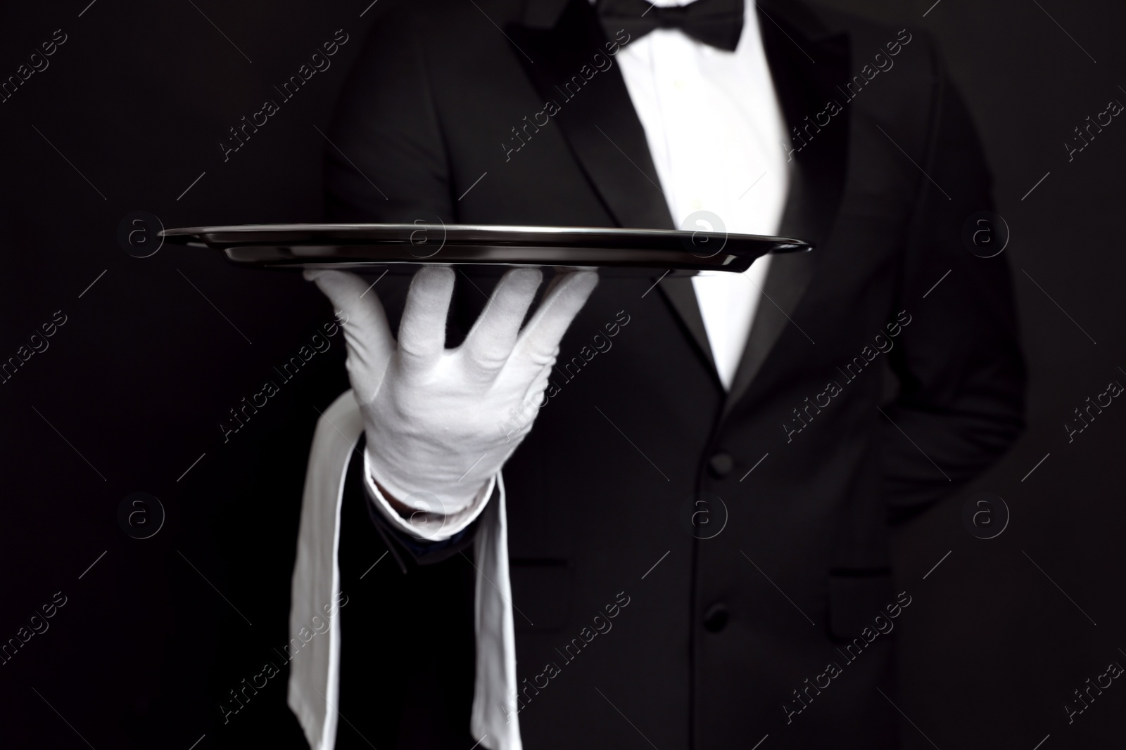 Photo of Butler with tray on black background, closeup
