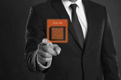 Image of Man pointing at illustration of QR code on dark background, closeup