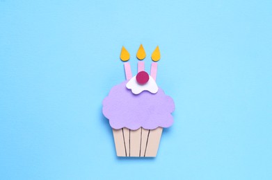 Birthday party. Paper cupcake on light blue background, top view