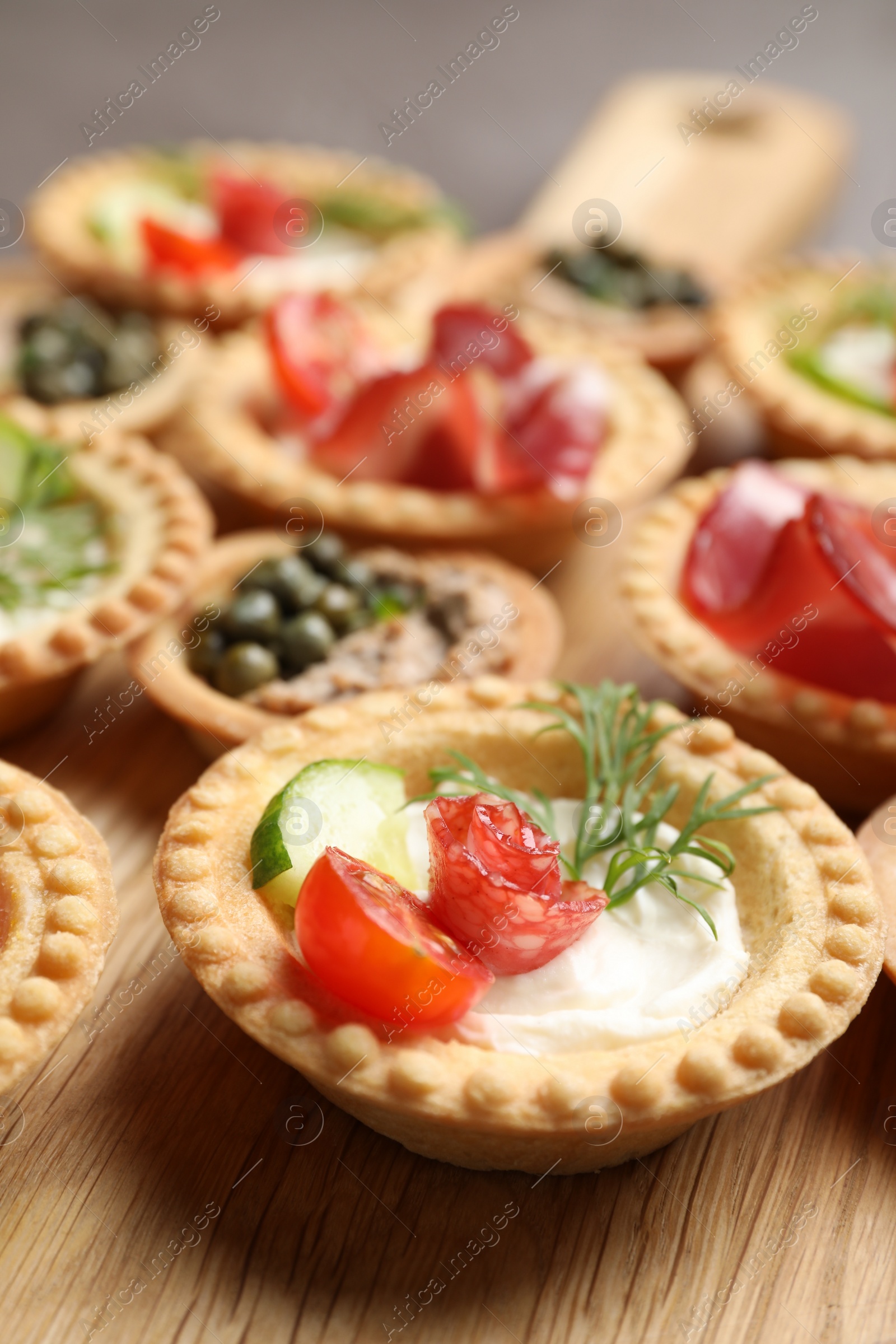 Photo of Delicious canapes with dry smoked sausage and cream cheese on table, closeup