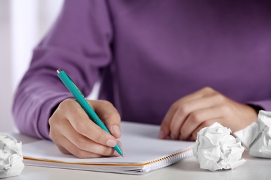 Photo of Woman working at table with crumpled paper, closeup. Generating idea