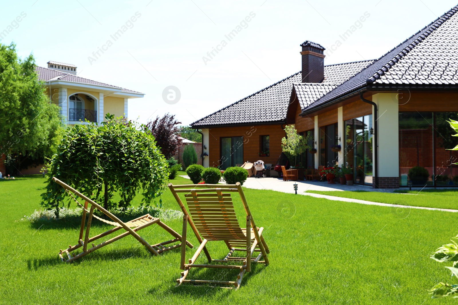 Photo of Wooden deck chairs in beautiful garden on sunny day