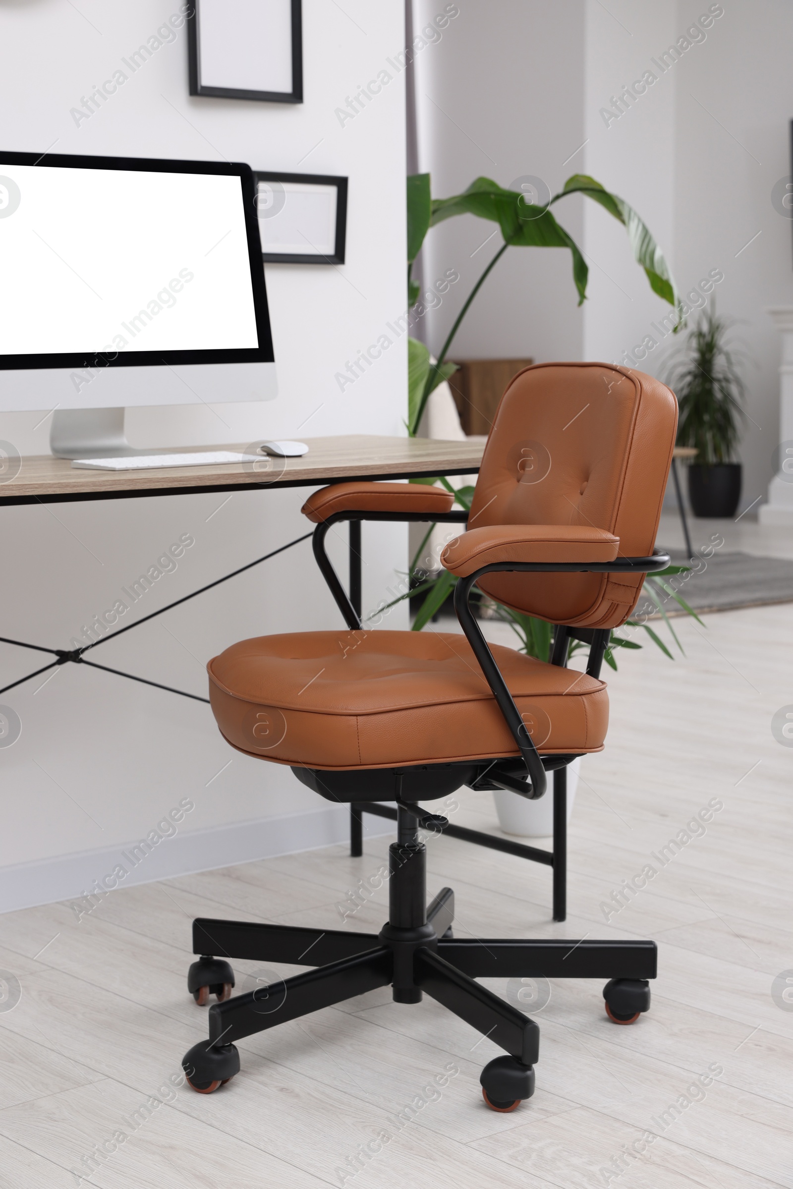 Photo of Stylish room interior with comfortable office chair, desk and houseplants